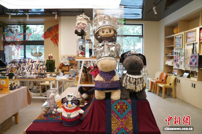 広西壮族自治区博物館文化クリエイティブグッズショップ内のDIYワークショップに並んでいる各種民族衣装を着たぬいぐるみ（撮影・王以照）。