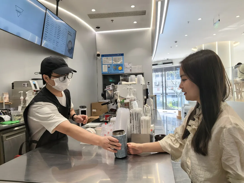 タンブラーを持参してコーヒーを買う女性（撮影・周心怡）。